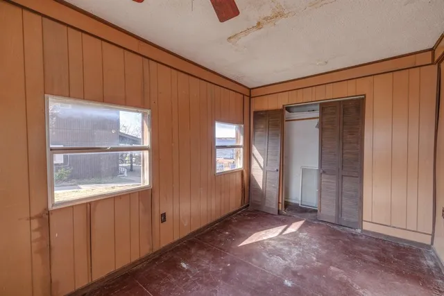 a view of a hallway with a glass door and chandelier fan