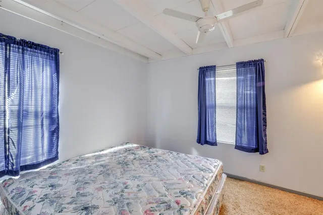 a spacious bedroom with a bed and a dresser