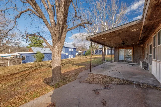 a view of a yard with a house and a large tree
