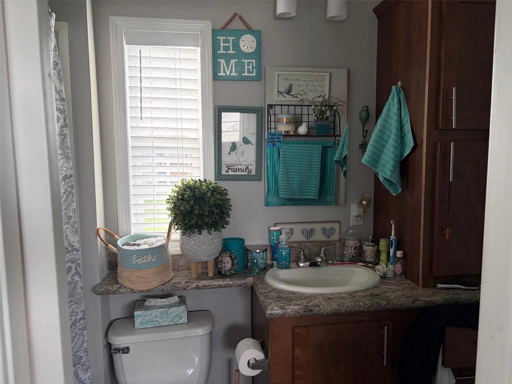 370 Sioux Quitman, TX 75783 - Photo 14 of 34 a bathroom with a granite countertop toilet sink and mirror