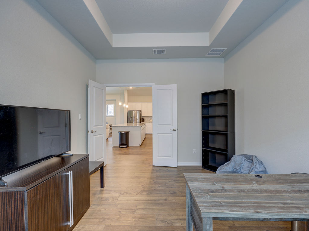 229 Heartleaf Road San Marcos, TX 78666 - Photo 10 of 40 Tray ceilings enhance this inviting study, offering seamless entry to a modern kitchen.