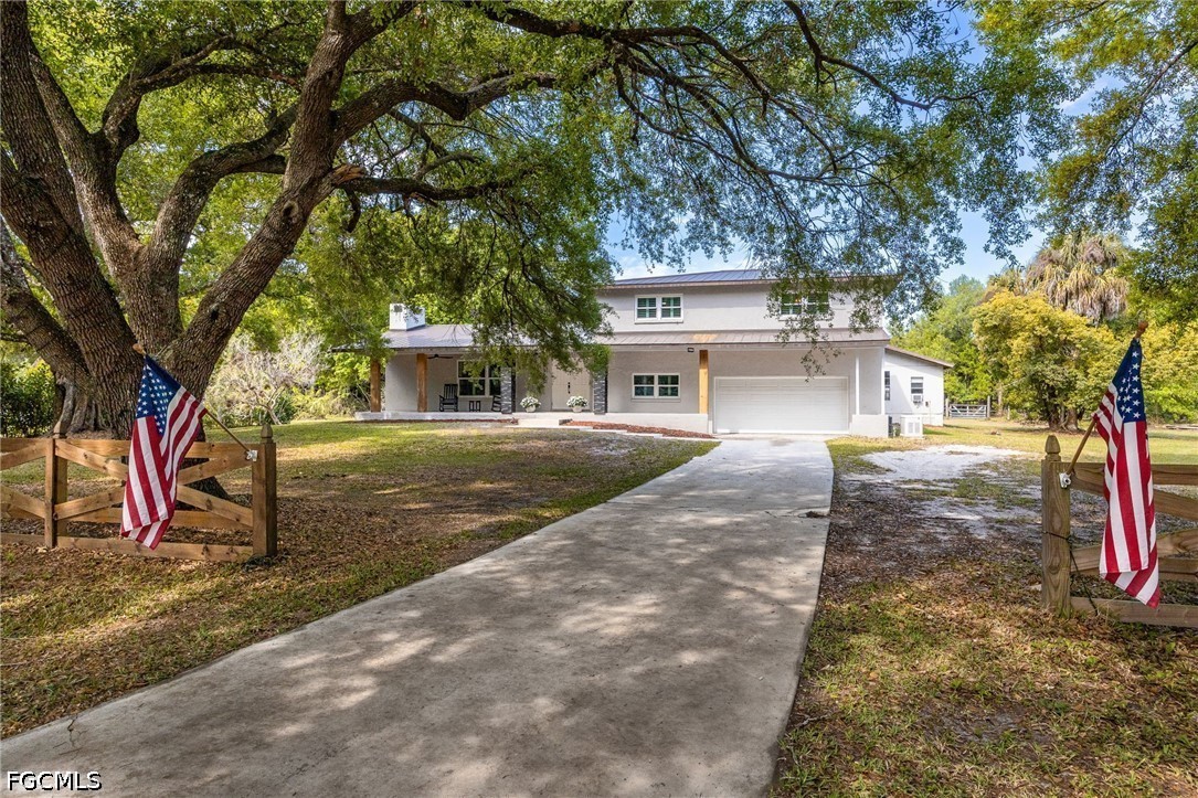 a front view of a house with a tree