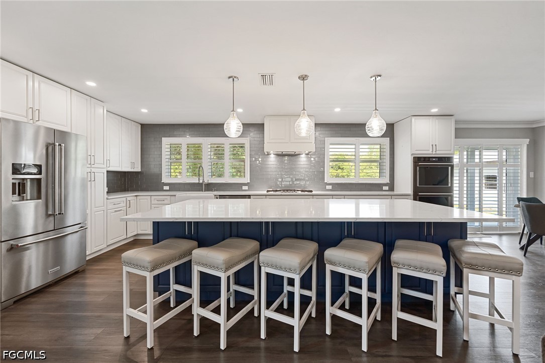 4220 Staley Road Fort Myers, FL 33905 - Photo 13 of 47 a kitchen with a dining table chairs wooden floor cabinets and appliances