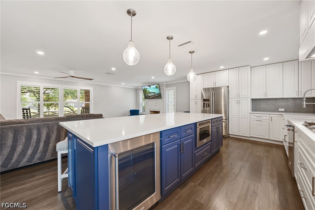 4220 Staley Road Fort Myers, FL 33905 - Photo 15 of 47 a large kitchen with stainless steel appliances a large center island wooden floor and a large window