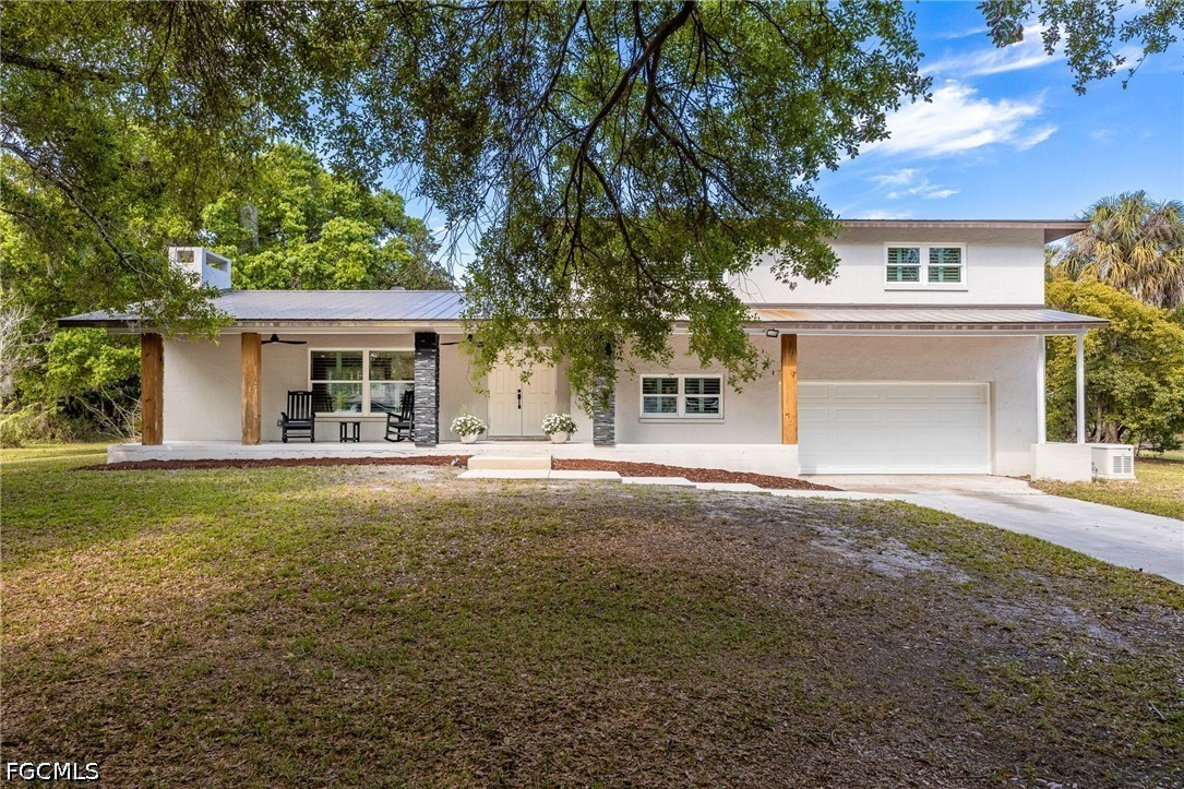 4220 Staley Road Fort Myers, FL 33905 - Photo 2 of 47 a front view of a house with a yard and a garage