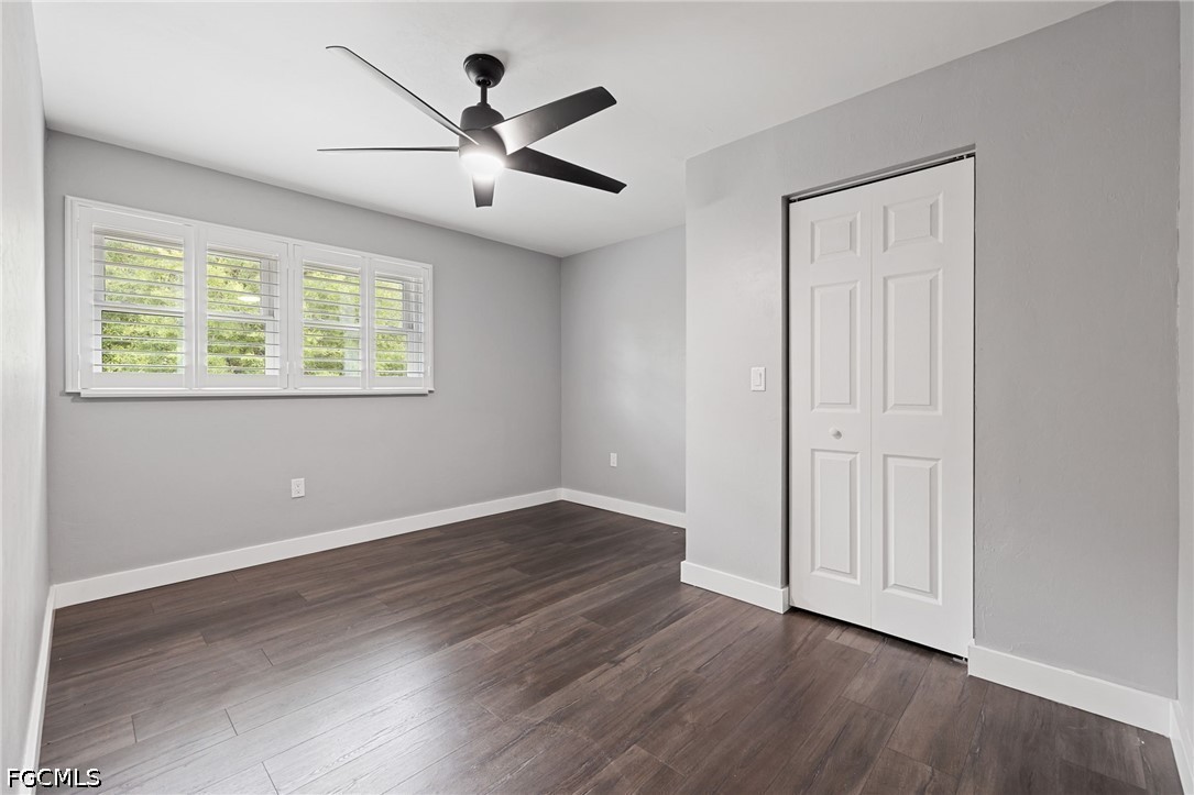 4220 Staley Road Fort Myers, FL 33905 - Photo 25 of 47 an empty room with wooden floor chandelier fan and windows