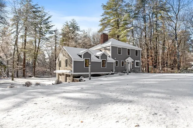a view of a house with a yard covered in snow