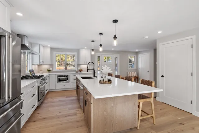a large white kitchen with stainless steel appliances