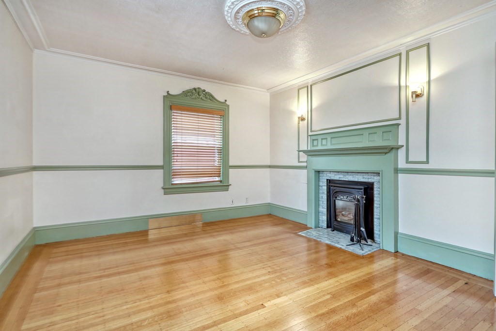 440 Broadway Somerville, MA 02145 - Photo 15 of 27 a view of empty room with fireplace and wooden floor