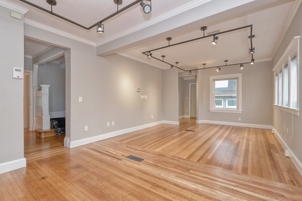 440 Broadway Somerville, MA 02145 - Photo 3 of 27 a view of an empty room with window and wooden floor
