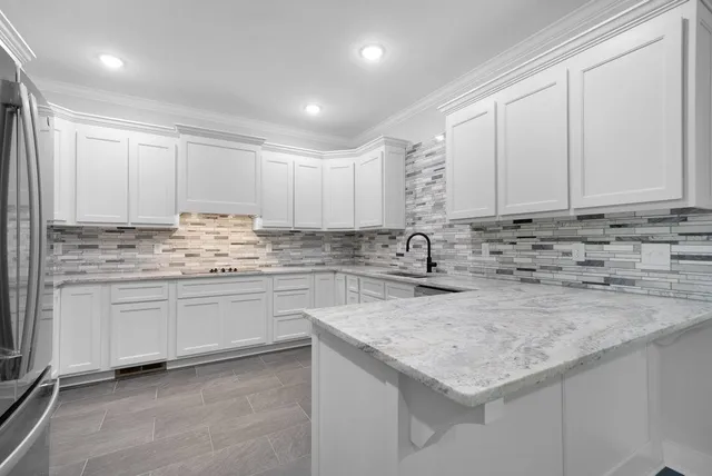 a kitchen with granite countertop white cabinets and white appliances