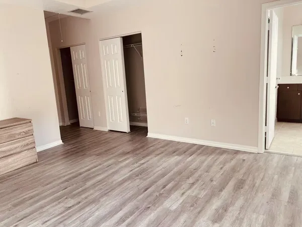 an empty room with wooden floor and closet