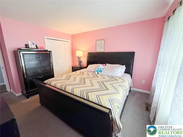 a bed sitting in a bedroom next to a window with tv