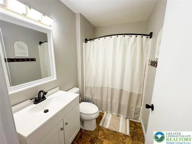 a bathroom with a sink mirror and a toilet