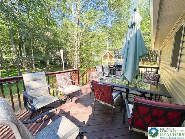a balcony with wooden floor table and chairs