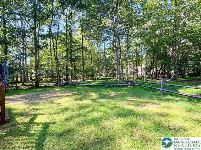 a view of yard with green space and trees