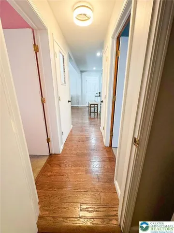 a view of a hallway with wooden floor and staircase
