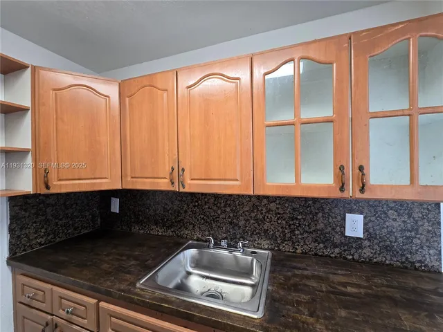 a kitchen with granite countertop a sink a granite counter tops and a large window