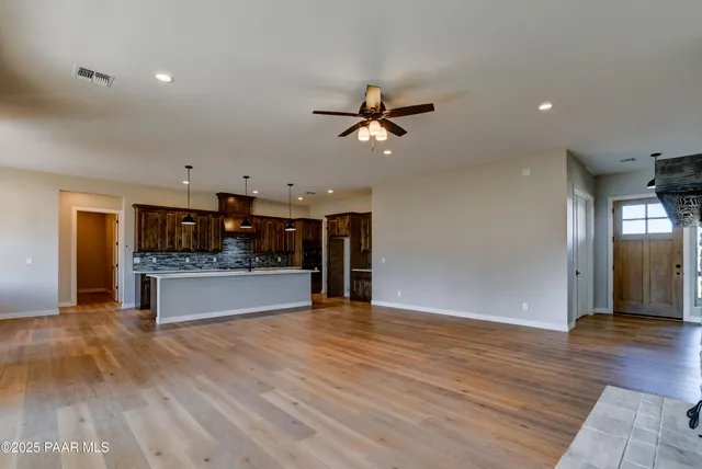 a kitchen with stainless steel appliances granite countertop a sink a stove and a wooden floors