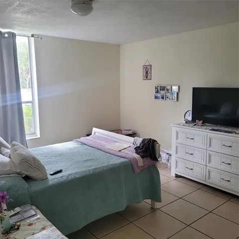 a bedroom with a bed and flat screen tv