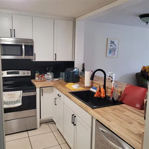 a kitchen with cabinets appliances and a sink