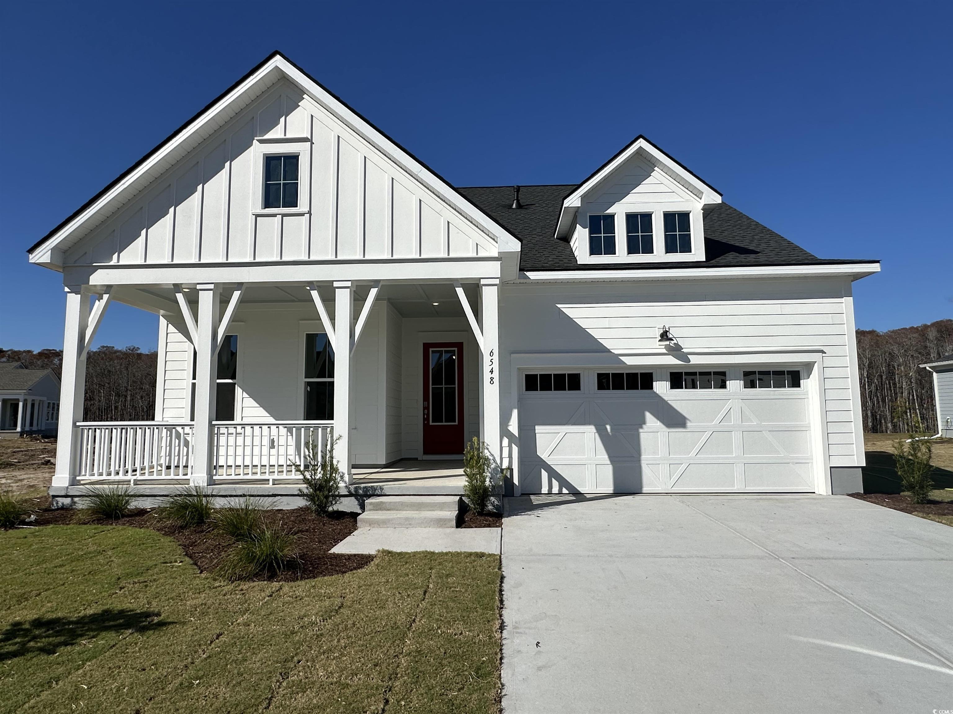6548 Berg Street Murrells Inlet, SC 29576 - Photo 1 of 1 Modern farmhouse style home with a front yard, covered porch, board and batten siding, a shingled roof, and a garage