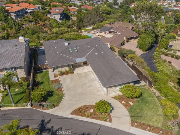 an aerial view of a house with a yard and a large tree