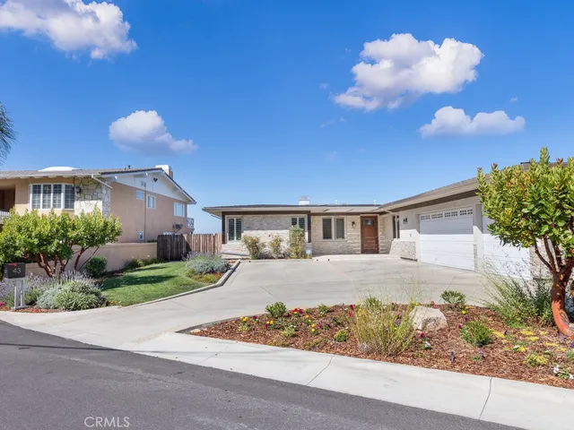 a view of a white house with a yard and a wooden fence