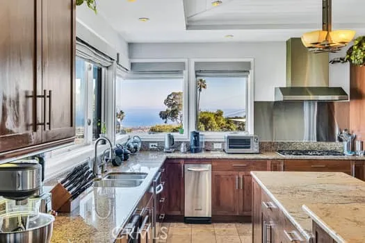 a large kitchen with granite countertop a sink and a stove