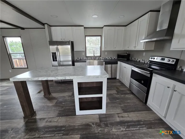 a kitchen with granite countertop a stove and a sink