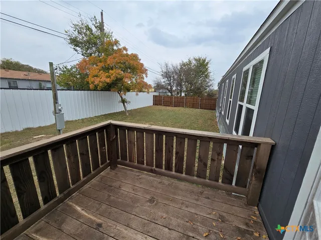 a balcony with wooden floor and fence