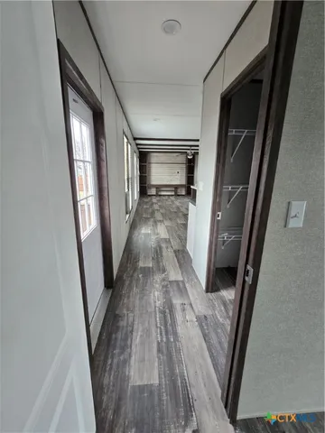 a view of a hallway with wooden floor and staircase
