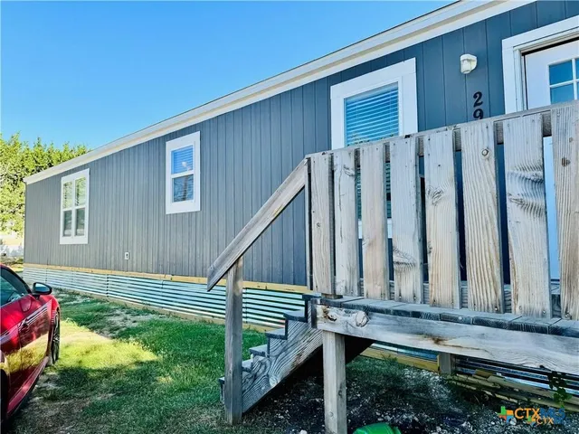 a view of a house with backyard and wooden fence