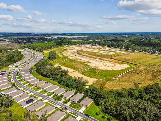 an aerial view of a house with a garden and lake view