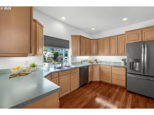 a kitchen with granite countertop stainless steel appliances a sink a counter top space and cabinets