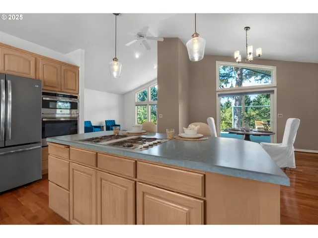 a kitchen with stainless steel appliances granite countertop a sink window and refrigerator