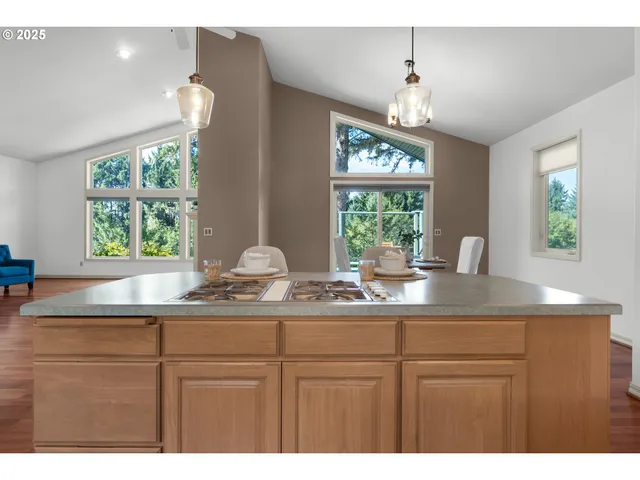 a kitchen with kitchen island white cabinets and a large window