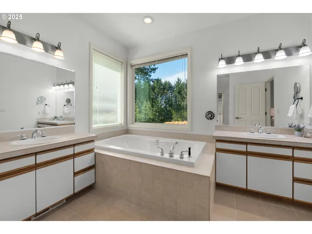 a bathroom with a tub sink and mirror