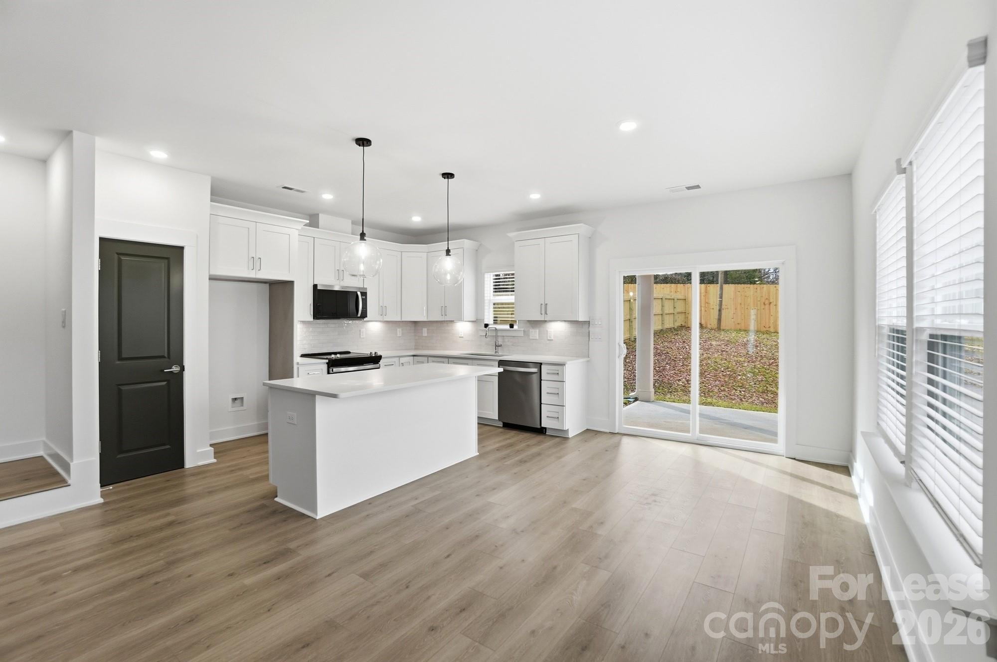 3945 Tillman Road Charlotte, NC 28208 - Photo 11 of 47 a kitchen with white cabinets and stainless steel appliances