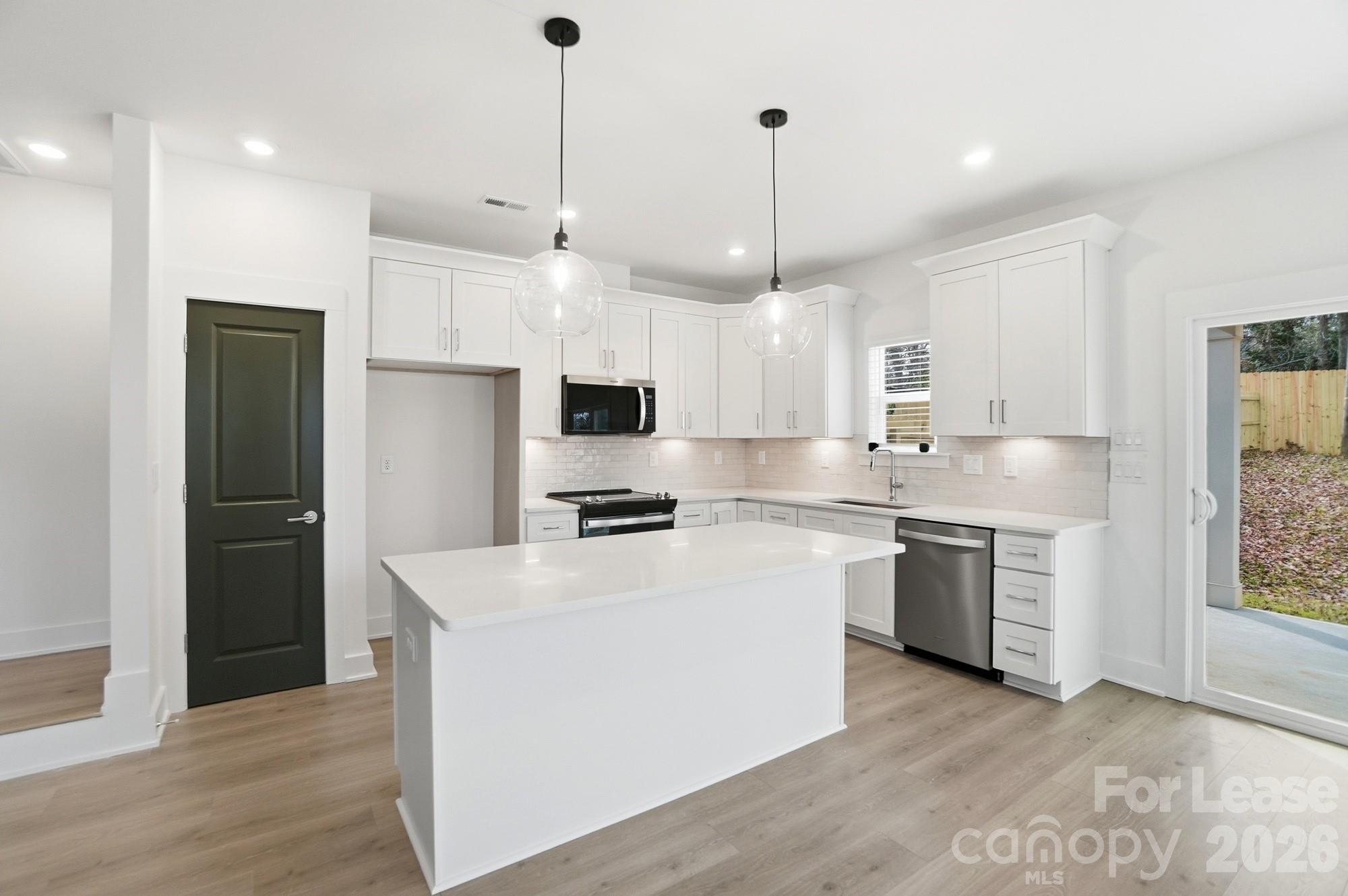 3945 Tillman Road Charlotte, NC 28208 - Photo 15 of 47 a kitchen with stainless steel appliances granite countertop a sink a stove a refrigerator and white cabinets