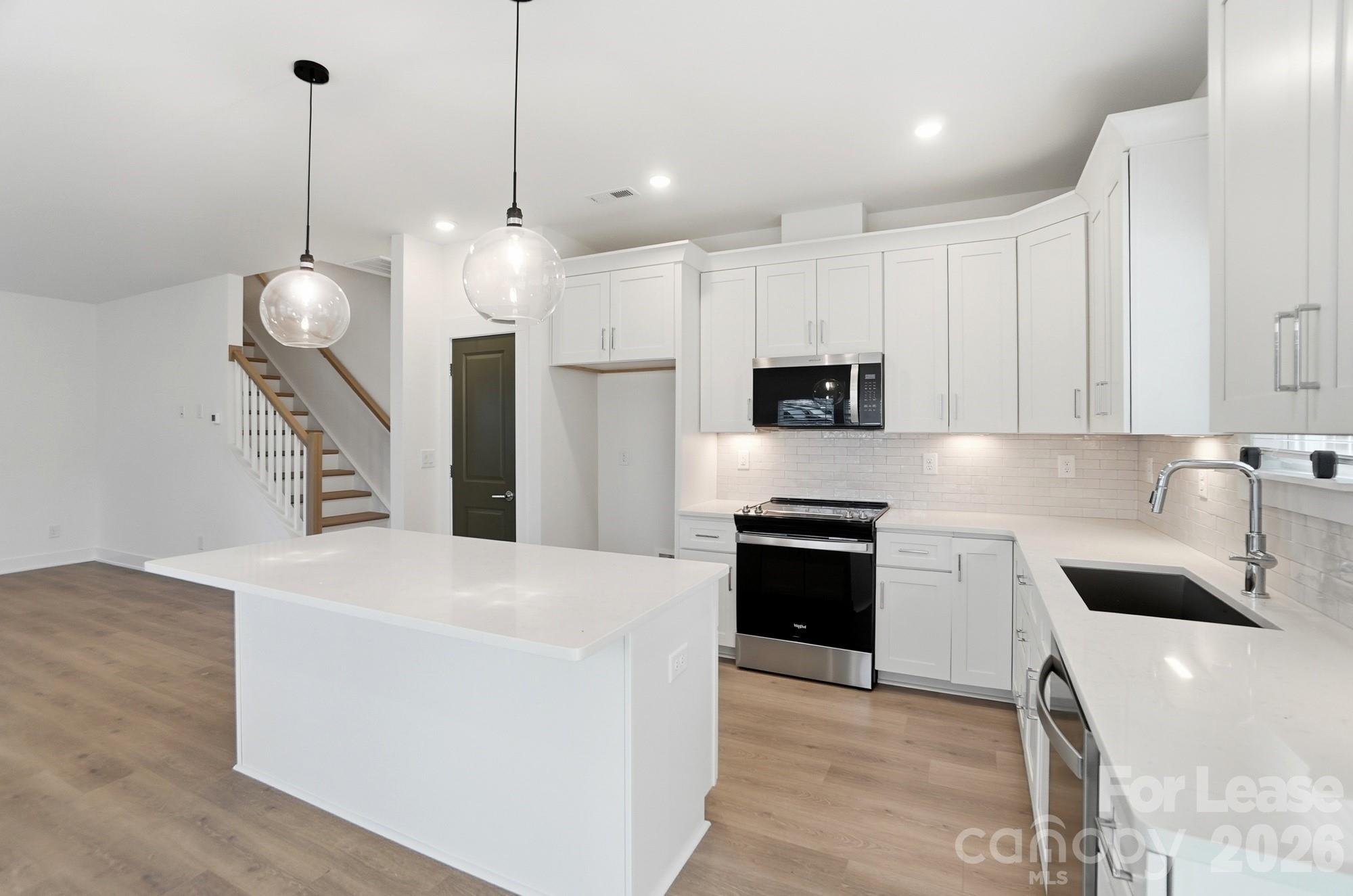 3945 Tillman Road Charlotte, NC 28208 - Photo 18 of 47 a kitchen with stainless steel appliances granite countertop a sink a stove and a refrigerator