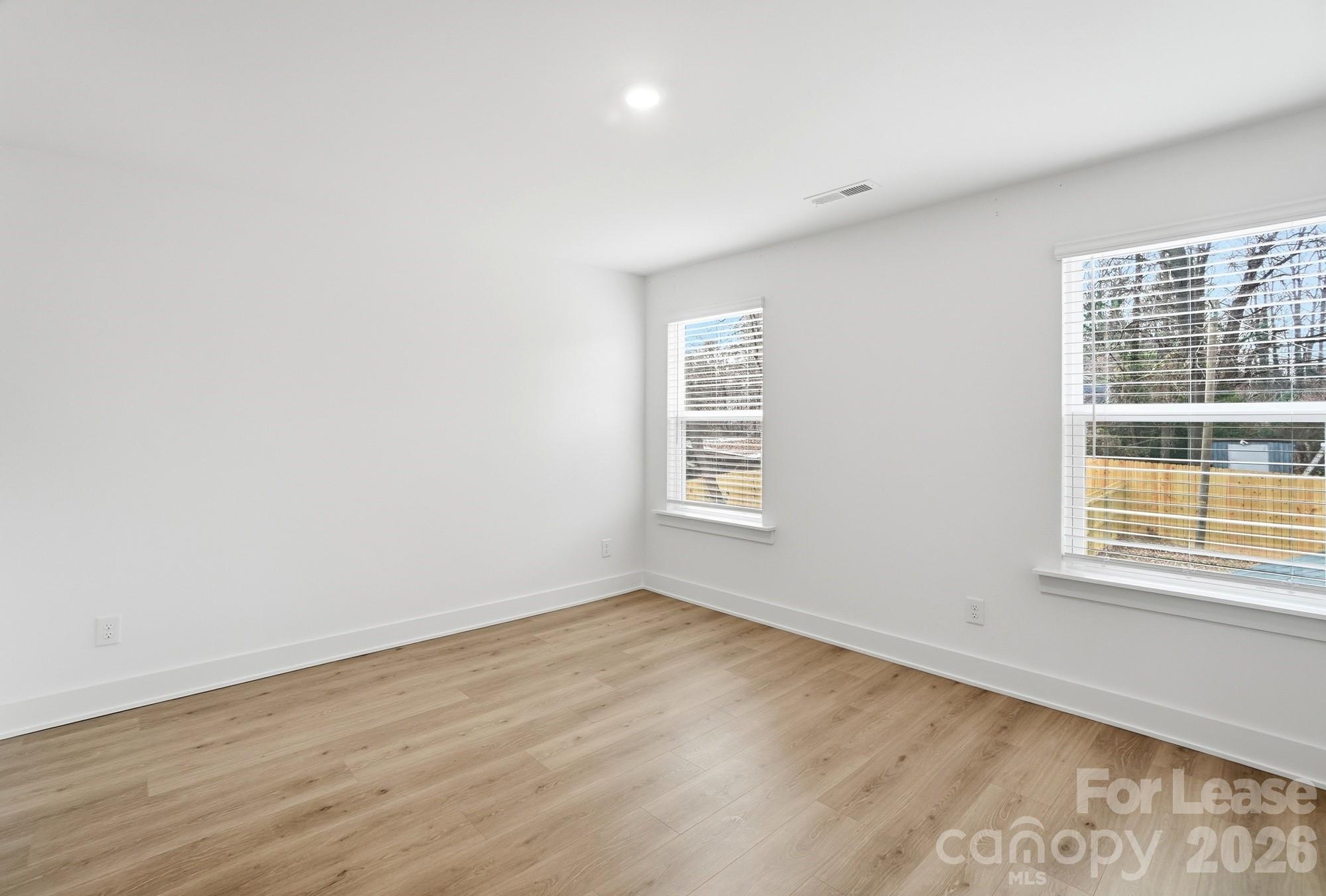 3945 Tillman Road Charlotte, NC 28208 - Photo 25 of 47 an empty room with wooden floor and windows