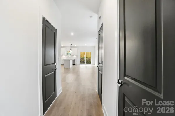 a view of a hallway with wooden floor windows and staircase