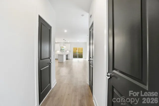 a view of a hallway with wooden floor windows and staircase