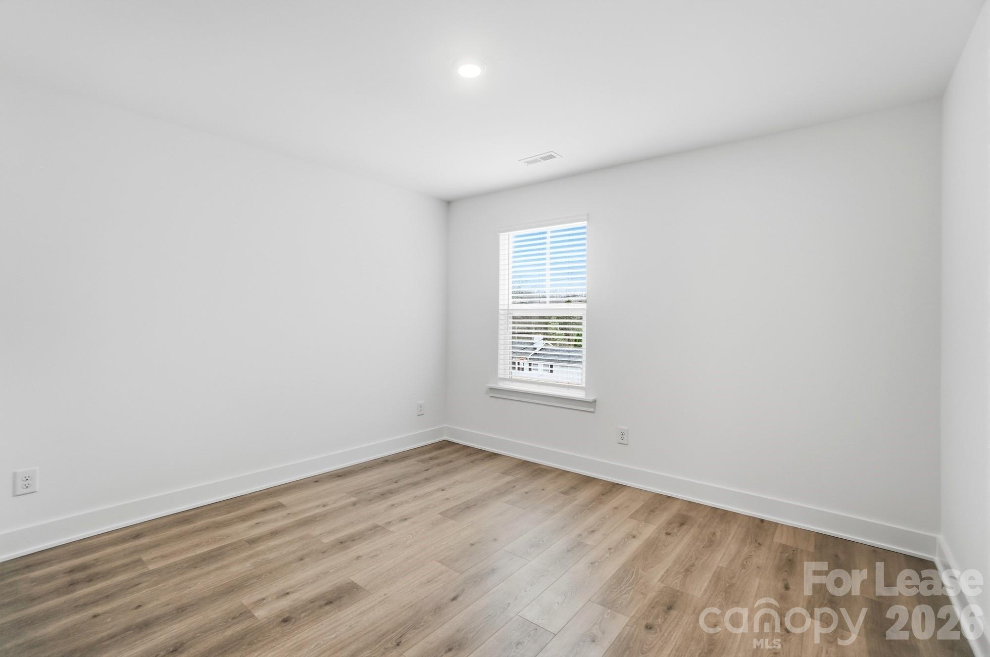 3945 Tillman Road Charlotte, NC 28208 - Photo 39 of 47 an empty room with wooden floor and windows