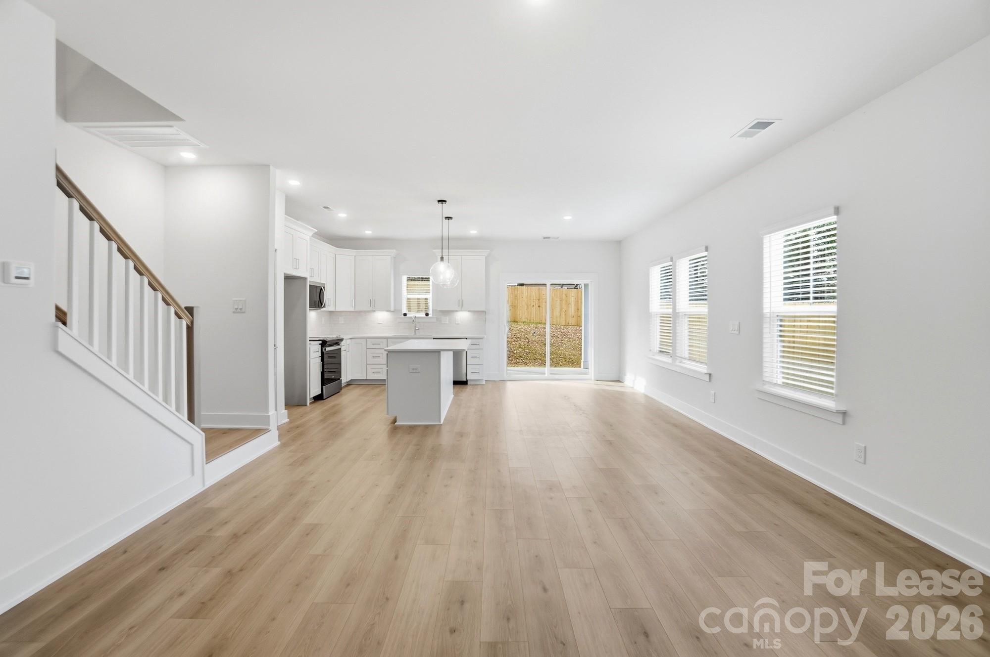 3945 Tillman Road Charlotte, NC 28208 - Photo 4 of 47 a view of an empty room with wooden floor and a window