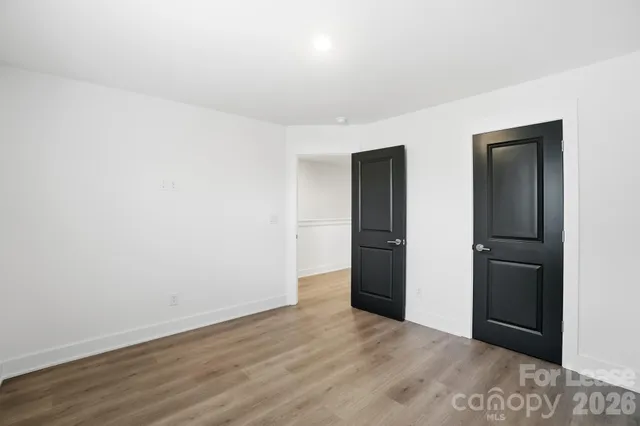 an empty room with wooden floor and closet
