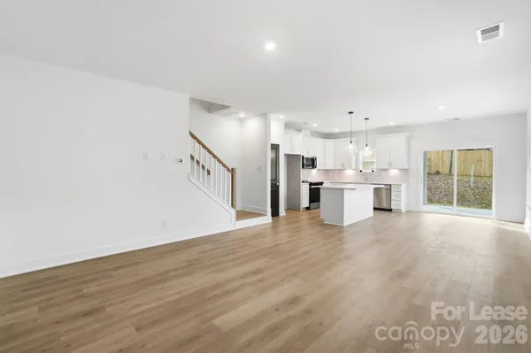 a view of a kitchen with a sink and dishwasher a refrigerator with wooden floor