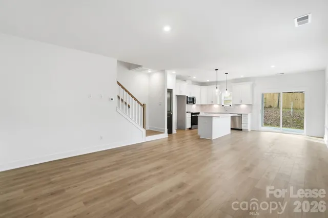 a view of a kitchen with a sink and dishwasher a refrigerator with wooden floor