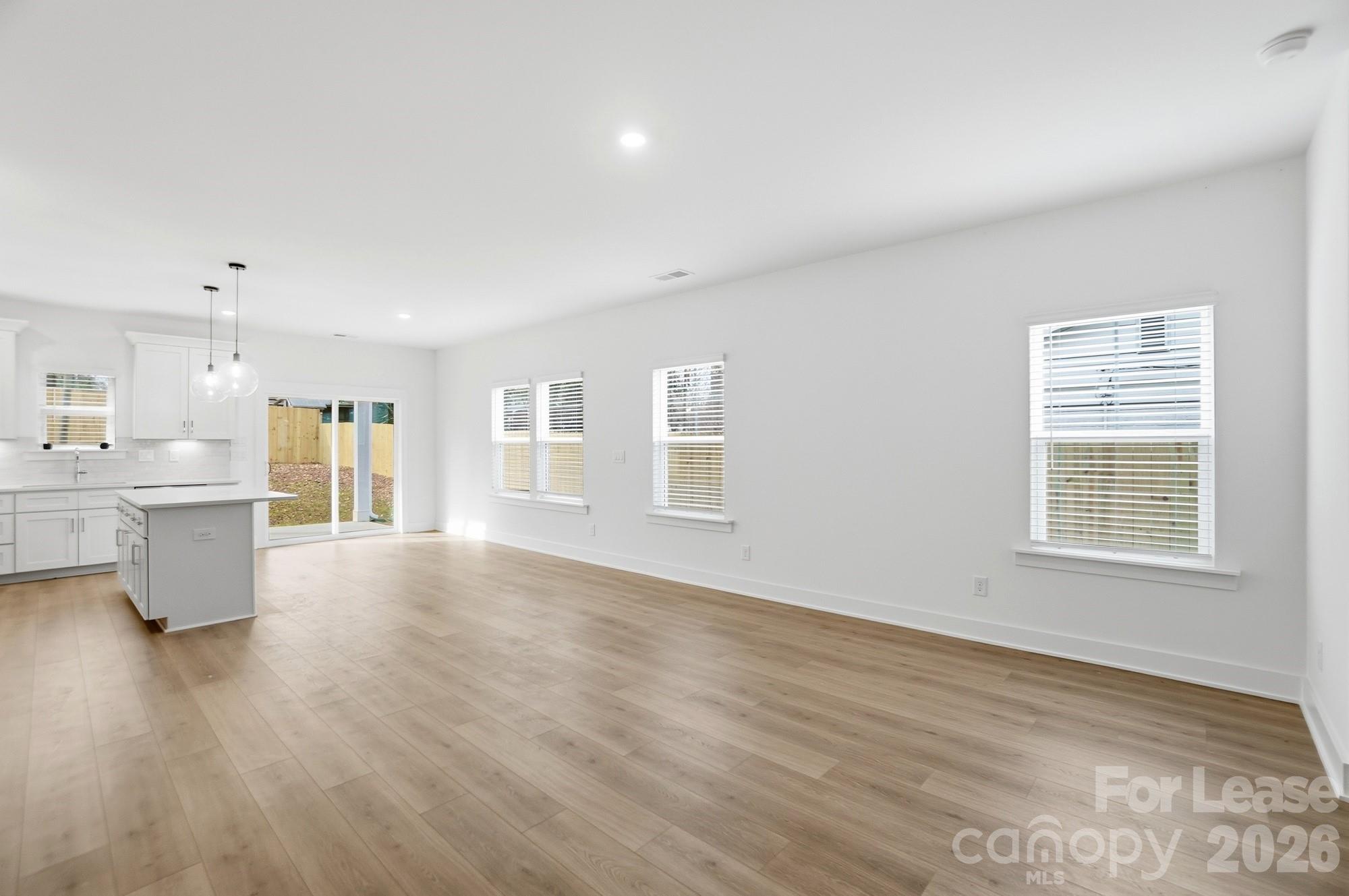 3945 Tillman Road Charlotte, NC 28208 - Photo 6 of 47 a view of an empty room with a window and wooden floor